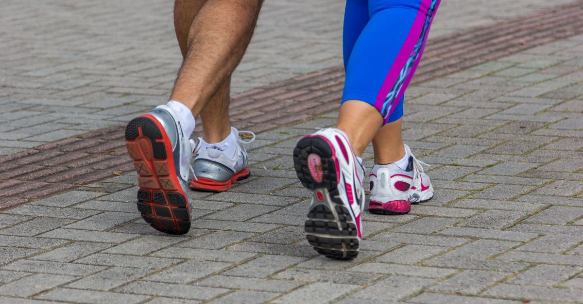 People jogging on a city street, giving a close-up of their sportswear shoes. Urban fitness scene.