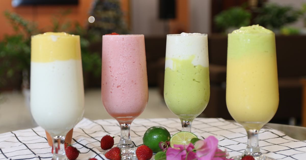 A vibrant array of healthy fruit smoothies in wine glasses, perfect for a balanced diet.