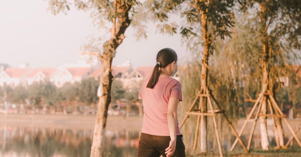 Woman walking in the serene park setting of Thành phố Bắc Ninh, Vietnam.