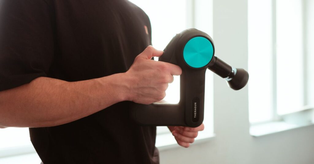 Close-up of a man using a massage device indoors with soft lighting.