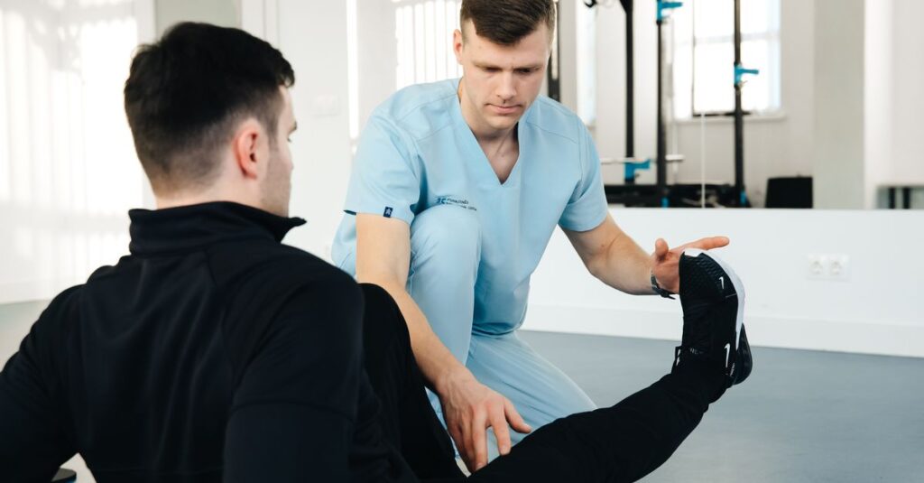 A physiotherapist assisting a patient in leg exercises during a rehabilitation session in a clinic setting.