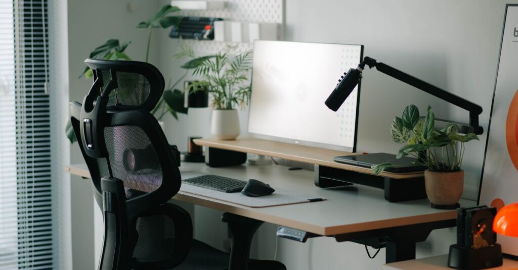 Stylish home office setup with ergonomic chair, plants, and modern desk accessories.
