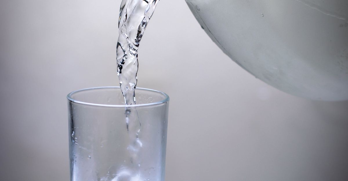 Crystal clear water being poured into a glass from a pitcher. Refreshing and hydrating concept.