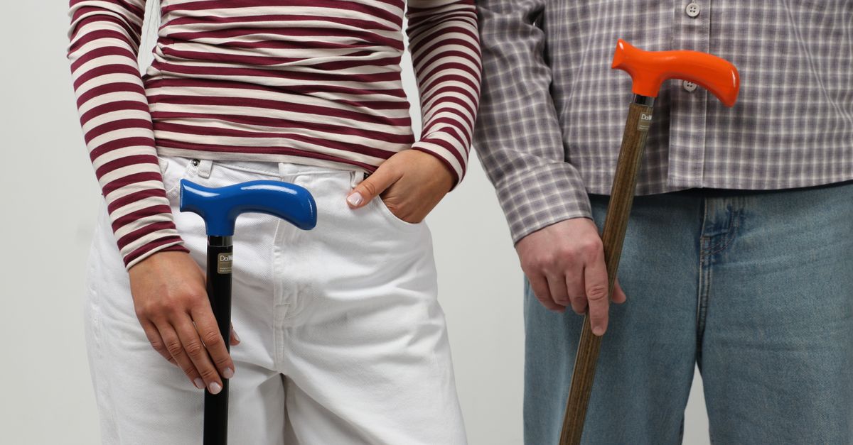Fashionable couple holding colorful walking canes, showcasing modern style.