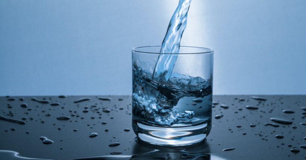 High-quality image of water being poured into a glass, illustrating hydration and purity.