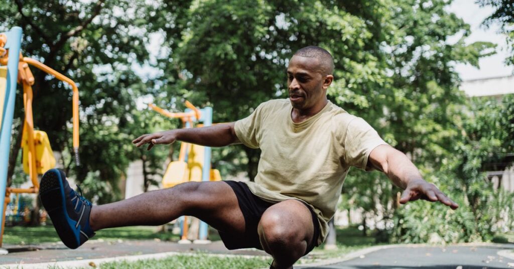 African American man practicing balance exercises in an outdoor park setting.