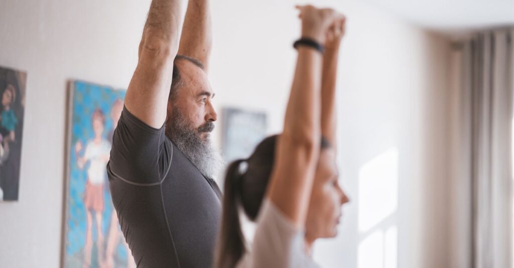 Senior couple engaging in morning yoga routine inside a bright room.