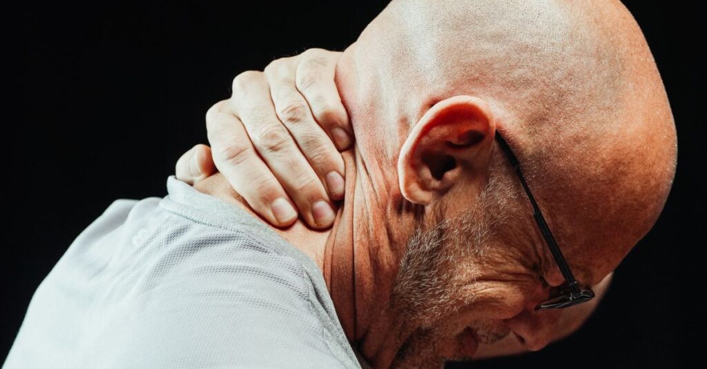 Side view of senior man holding neck with visible discomfort, highlighting neck pain relief.