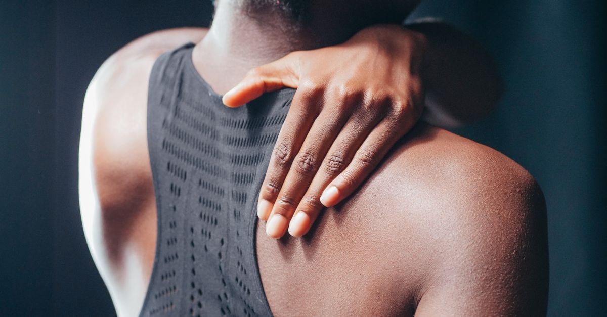 A close-up shot of a person touching their shoulder, emphasizing texture and form.