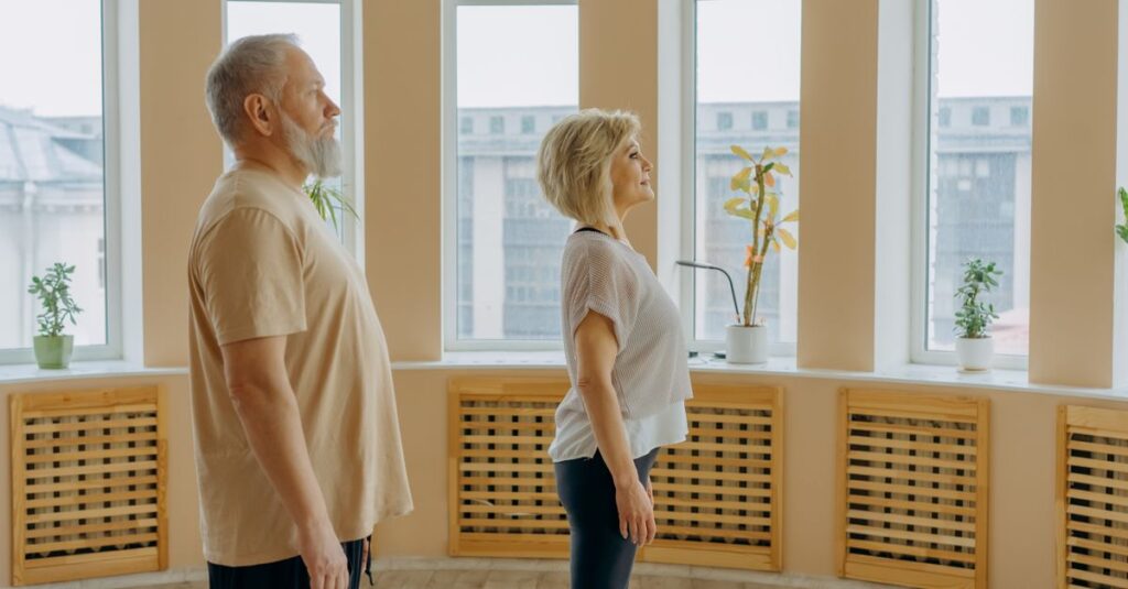 Side view of middle aged serious couple in casual clothes standing in spacious room near windows with potted plants on windowsill in daytime