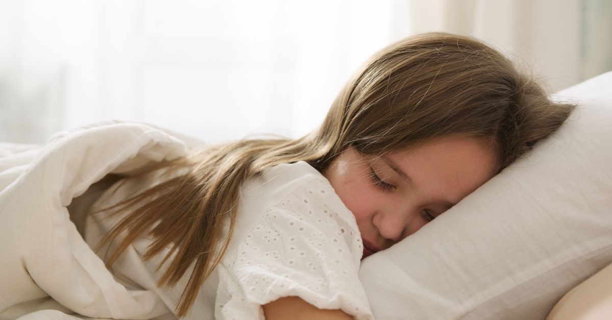 A young girl peacefully sleeping on a pillow, enveloped in soft light and comfort.