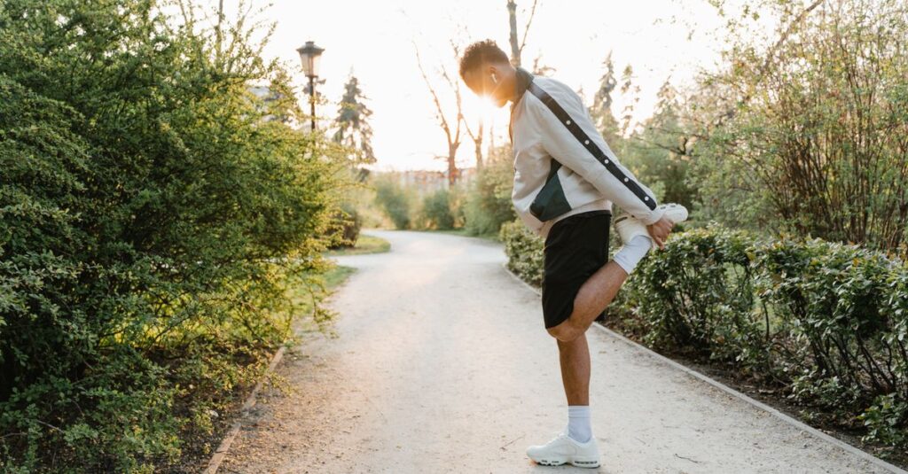 An adult man stretches in a park, enjoying a healthy exercise routine at sunrise for a fit lifestyle.