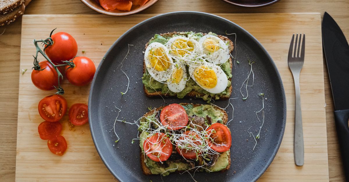 Delicious avocado toast topped with fresh eggs and tomatoes, perfect for a healthy breakfast or lunch.