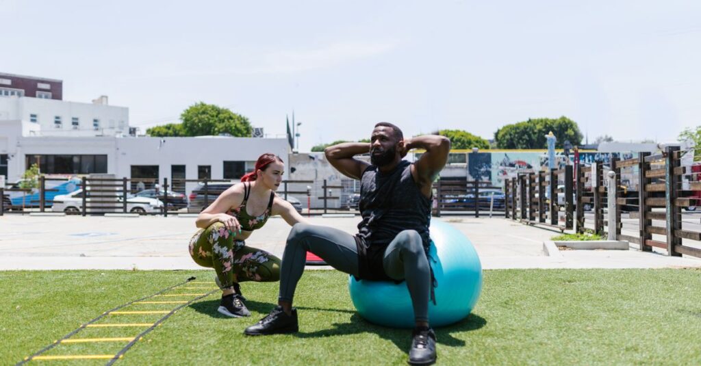 Man and woman engaged in fitness activities outdoors using an exercise ball.