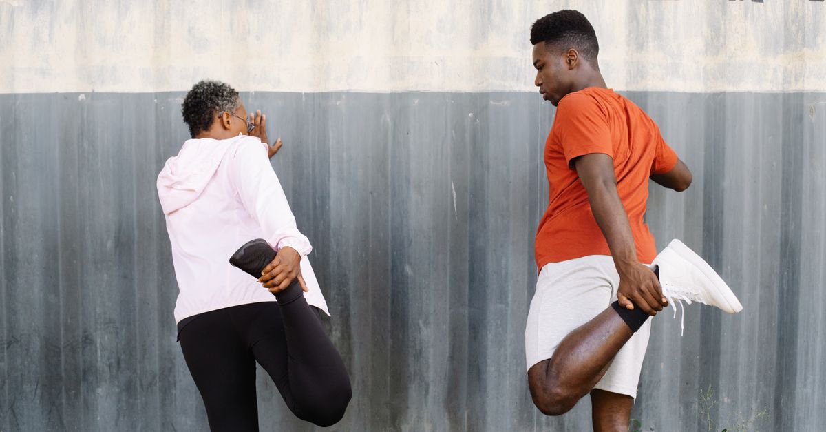 Two adults stretching outdoors with 'Queens Bridge' sign in background.